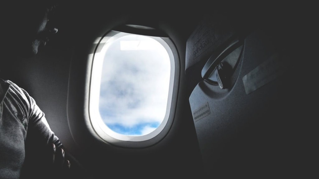 A man sites in an airplane next to the window, showing how prepreg composites benefit from S-LEC B/K polyvinyl acetal resin.